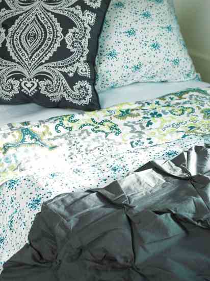 West Elm's organic Pin-Tuck duvet cover in slate, Plover Organic's reversible organic cotton duvet cover in Cartouche/Teal Confetti, and Amy Butler's Bucharest & Constanta throw pillow